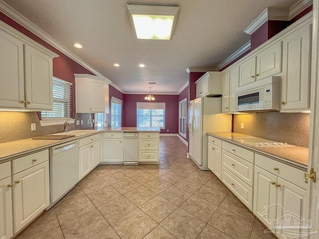 3615 Ward Basin Rd, Milton, FL 32583 - kitchen with white appliances, a peninsula, crown molding, light countertops, and backsplash