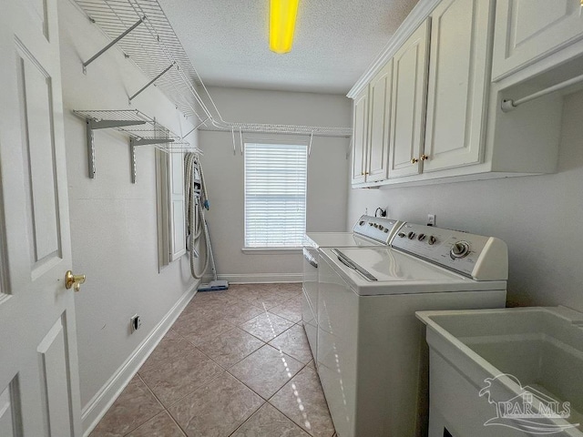 3615 Ward Basin Rd, Milton, FL 32583 - laundry area with separate washer and dryer, cabinet space, light tile patterned flooring, baseboards, and a textured ceiling