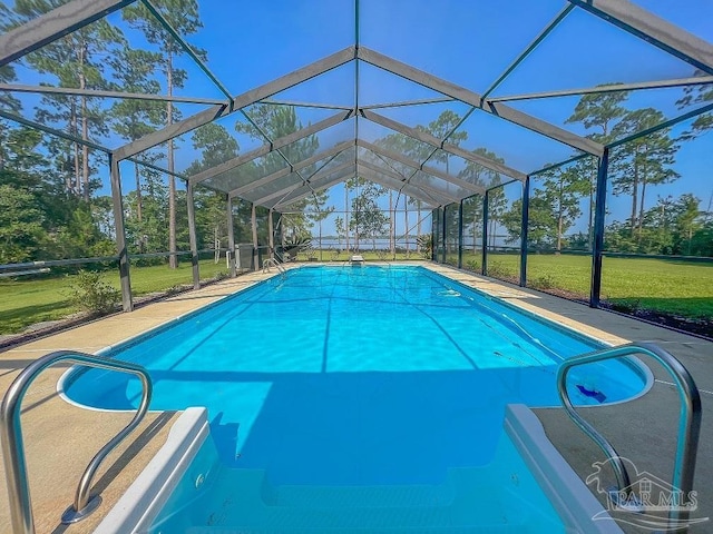 view of pool featuring a lawn and a lanai