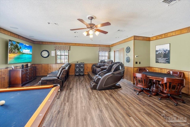 playroom featuring ceiling fan, hardwood / wood-style floors, a textured ceiling, and wood walls