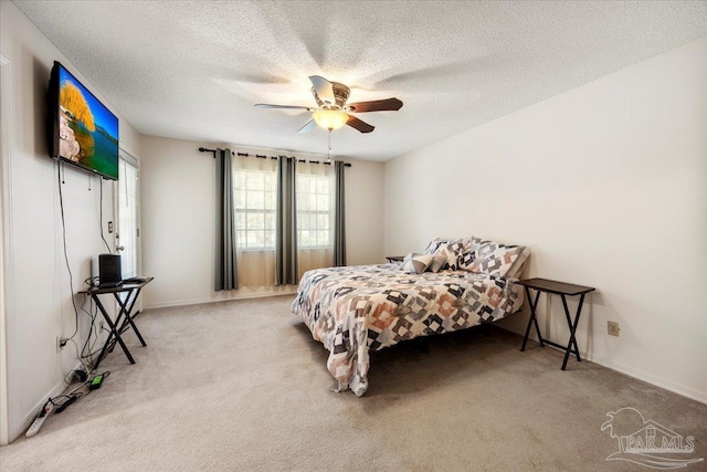 bedroom with ceiling fan, light carpet, and a textured ceiling