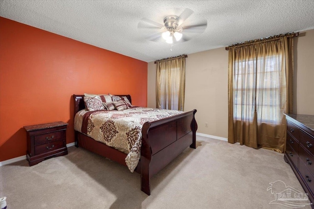 carpeted bedroom with ceiling fan and a textured ceiling