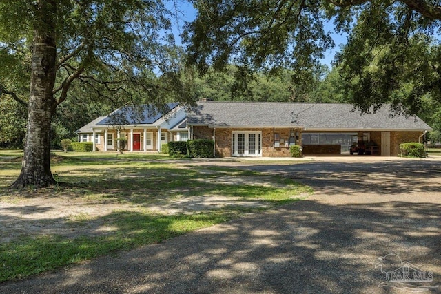 ranch-style house with a front yard and french doors