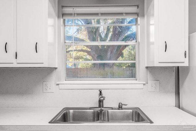 kitchen featuring white cabinets, plenty of natural light, and sink