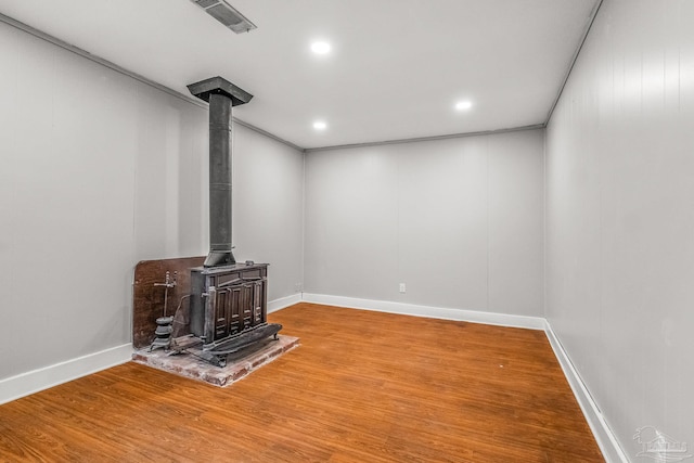 living room featuring a wood stove and wood-type flooring