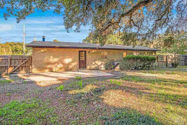 back of house with a yard and a patio