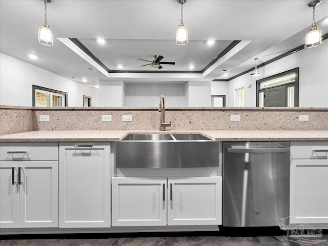 kitchen with sink, dishwasher, hanging light fixtures, a tray ceiling, and white cabinets