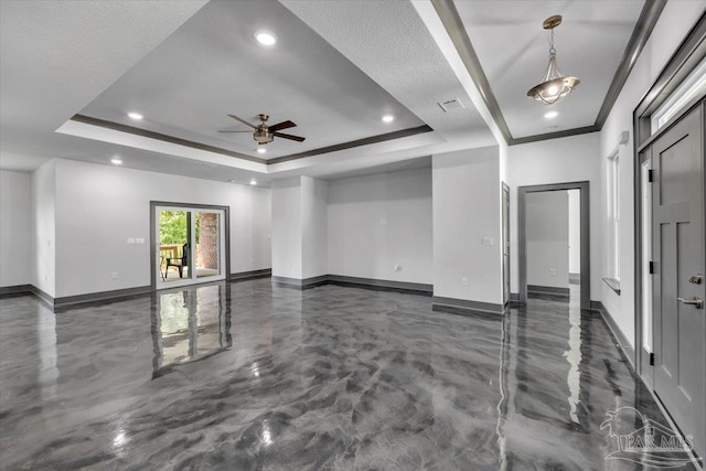 spare room featuring a raised ceiling, ornamental molding, and ceiling fan