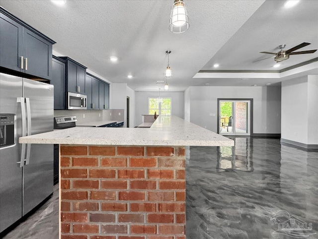 kitchen with a textured ceiling, a kitchen breakfast bar, pendant lighting, stainless steel appliances, and light stone countertops