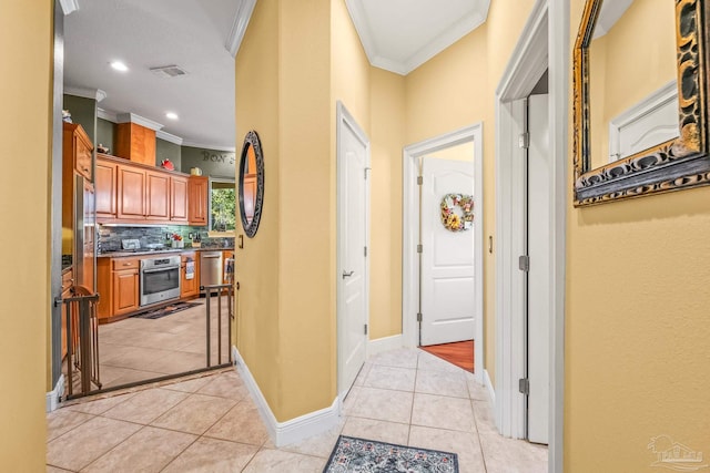 hallway with ornamental molding and light tile patterned floors