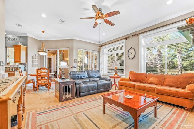 living room with ceiling fan, a healthy amount of sunlight, light tile patterned flooring, and crown molding