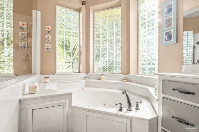 bathroom with vanity, a wealth of natural light, and a bathing tub