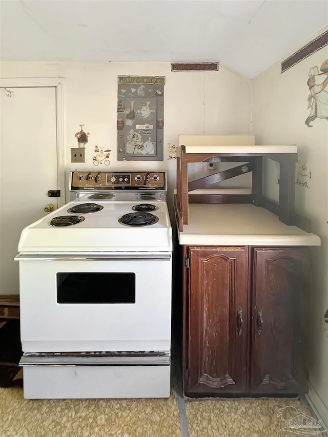 kitchen featuring dark brown cabinetry and white range with electric cooktop