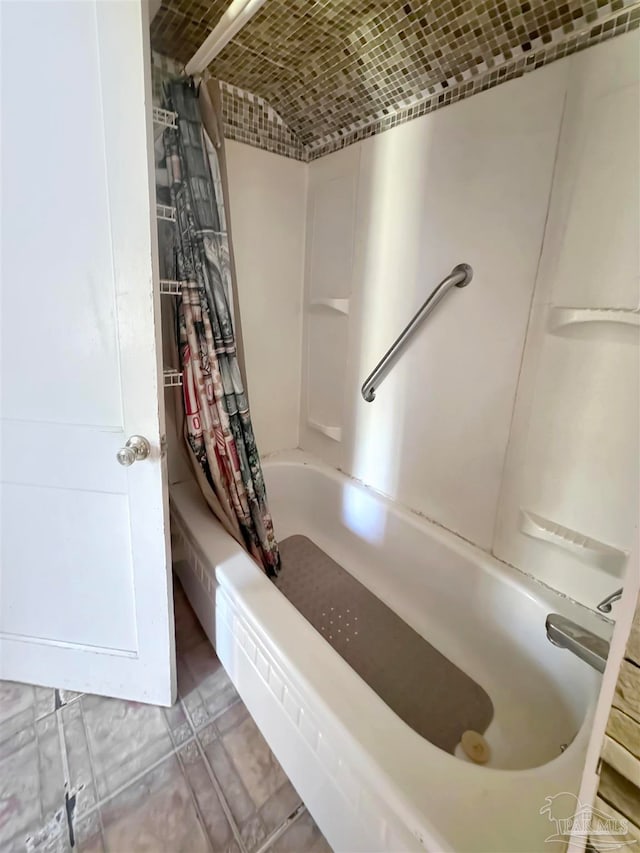 bathroom with tile patterned floors and shower / bath combo with shower curtain