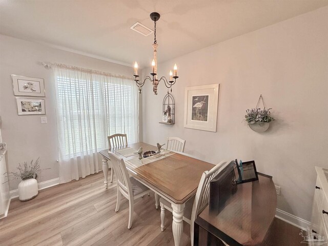 405 Waterbury Ct, Cantonment, FL 32533 - dining area with a chandelier, light wood finished floors, and baseboards