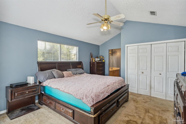 bedroom with a closet, lofted ceiling, light colored carpet, and ceiling fan