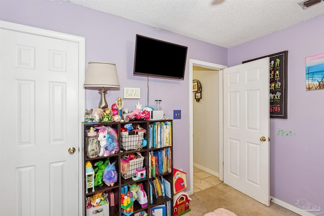 game room with light carpet and a textured ceiling