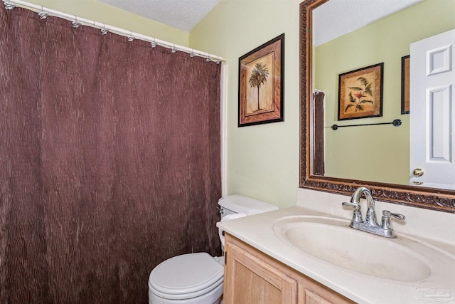 bathroom with vanity, a textured ceiling, and toilet