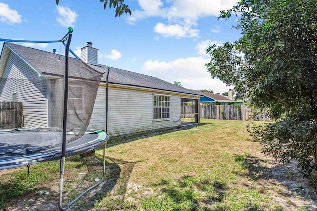 exterior space with a trampoline and a yard