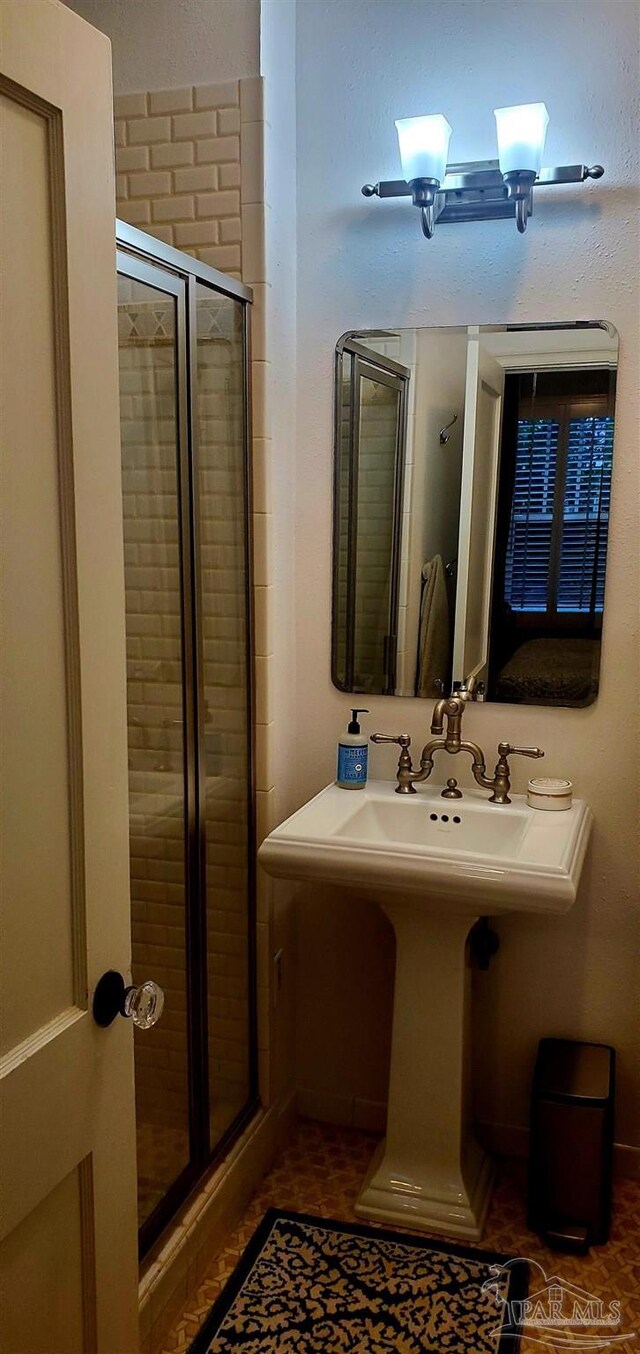 bathroom featuring tile patterned flooring and an enclosed shower