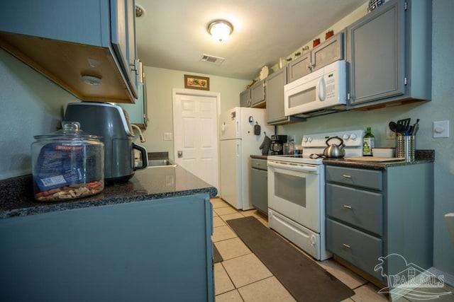 8687 John Hamm Rd, Milton, FL 32583 - kitchen with white appliances, light tile patterned floors, a sink, and blue cabinets