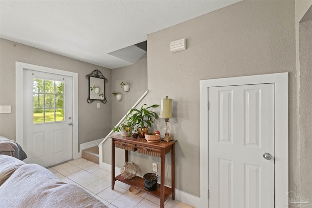 foyer entrance with light tile patterned floors, baseboards, and stairs