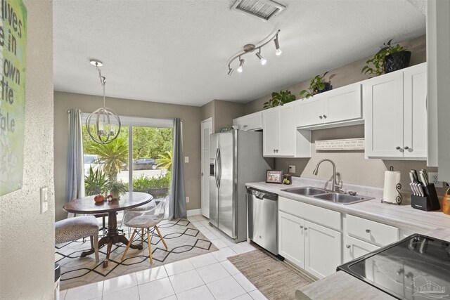 kitchen featuring visible vents, a sink, appliances with stainless steel finishes, white cabinets, and light countertops