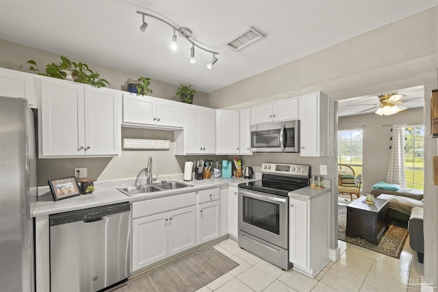 kitchen featuring visible vents, a sink, white cabinetry, appliances with stainless steel finishes, and light countertops