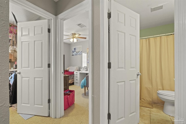 full bathroom featuring visible vents, toilet, a shower with curtain, and a ceiling fan