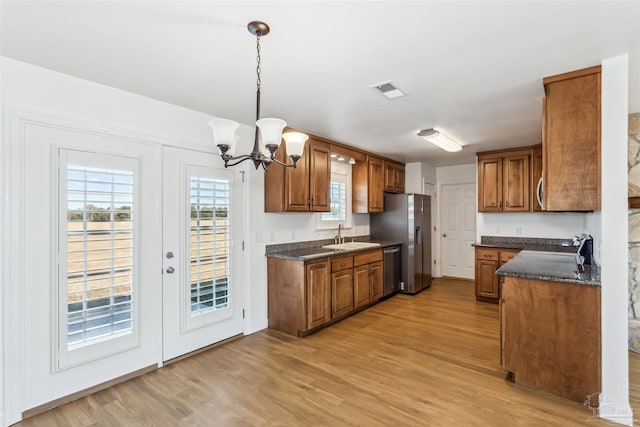 kitchen with dishwasher, pendant lighting, a notable chandelier, and light wood-type flooring