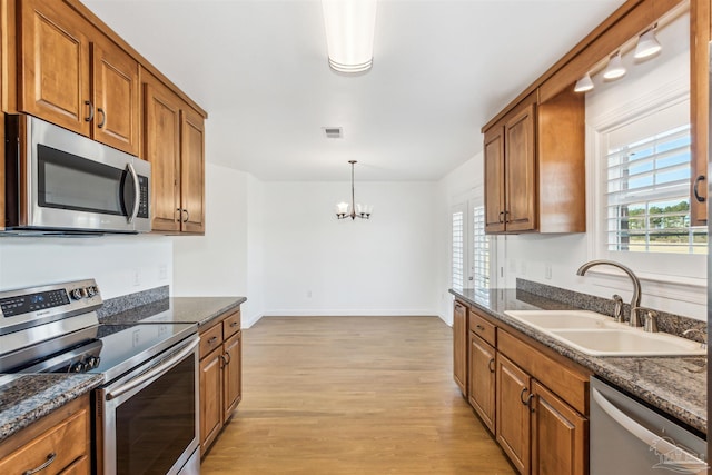 kitchen featuring plenty of natural light, sink, light wood-type flooring, and stainless steel appliances