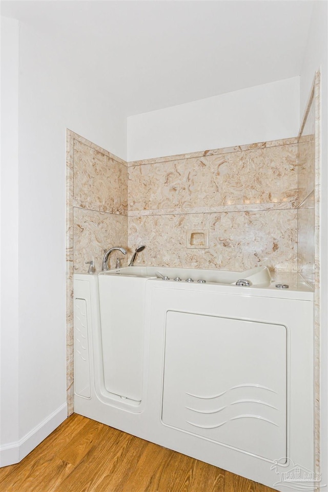 bathroom featuring wood-type flooring and washer / clothes dryer