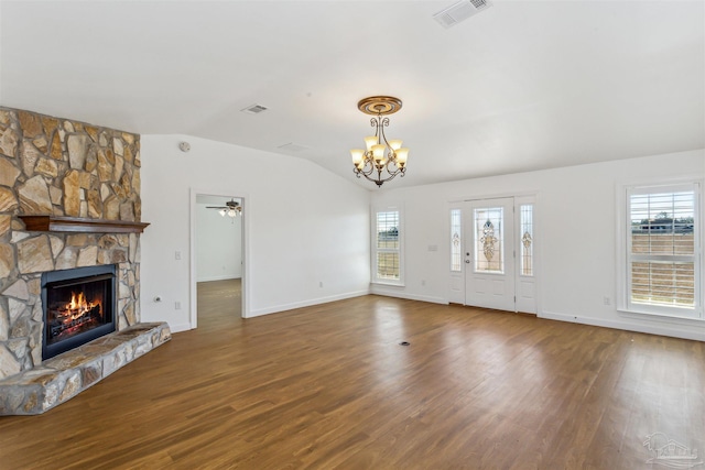 unfurnished living room with hardwood / wood-style floors, ceiling fan with notable chandelier, a fireplace, and vaulted ceiling