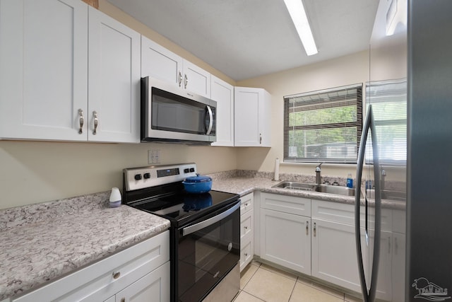 702 Beauvais Rd, Pensacola, FL 32505 - kitchen with white cabinetry, appliances with stainless steel finishes, light tile patterned flooring, light countertops, and a sink
