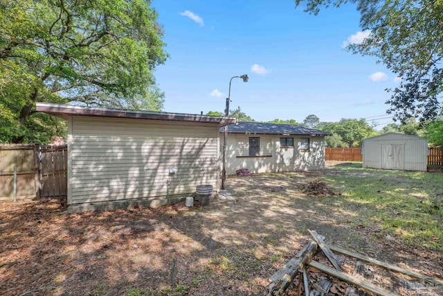 702 Beauvais Rd, Pensacola, FL 32505 - rear view of property with a storage shed, fence, and an outdoor structure