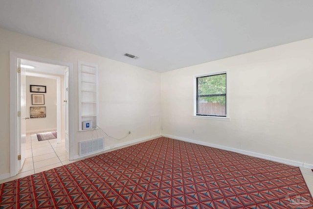 702 Beauvais Rd, Pensacola, FL 32505 - spare room with tile patterned floors, built in shelves, visible vents, and baseboards