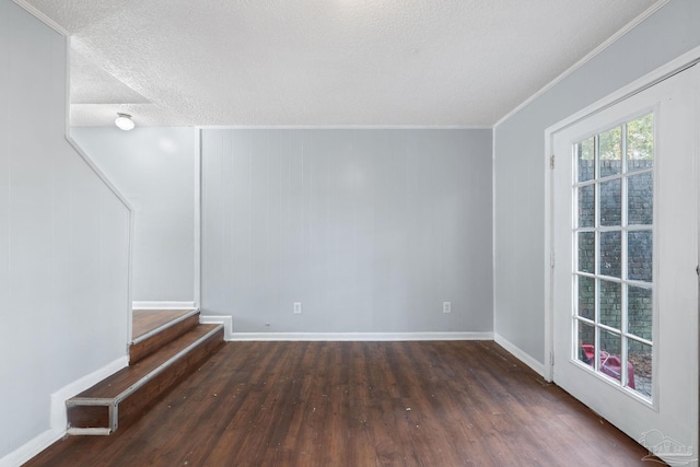 unfurnished room featuring a textured ceiling, dark hardwood / wood-style floors, and ornamental molding