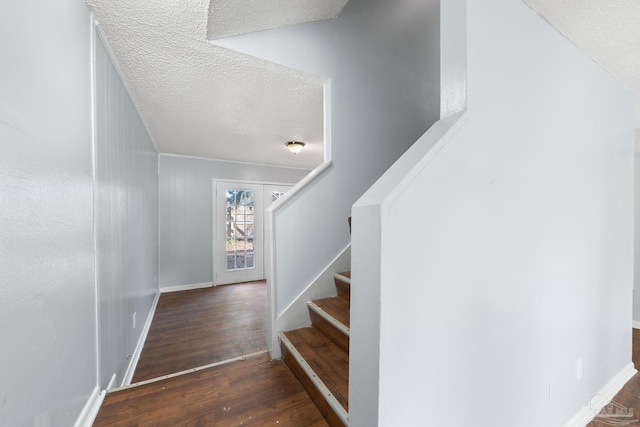 stairs featuring hardwood / wood-style floors and a textured ceiling