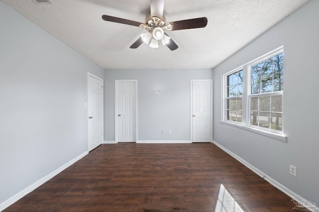 spare room featuring a textured ceiling, ceiling fan, and dark wood-type flooring