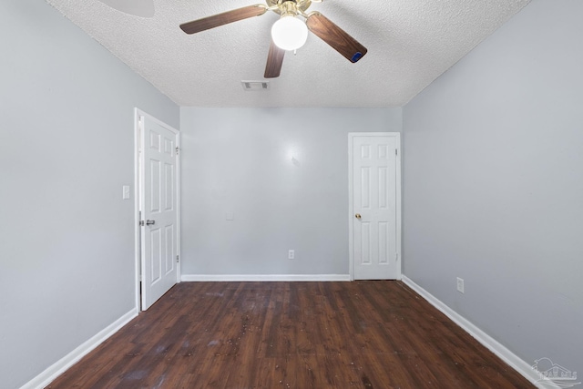 unfurnished room with ceiling fan, dark hardwood / wood-style flooring, and a textured ceiling