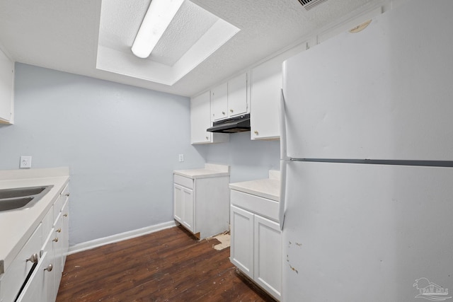 kitchen featuring dark wood-type flooring, white cabinets, sink, a textured ceiling, and white fridge