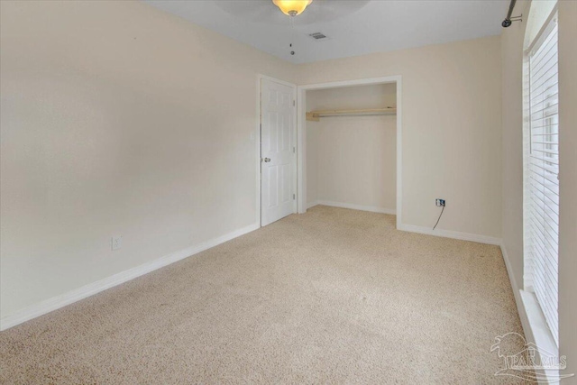 unfurnished bedroom with a closet, carpet flooring, and ceiling fan