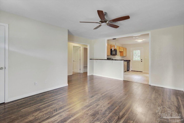 unfurnished living room with hardwood / wood-style flooring and ceiling fan