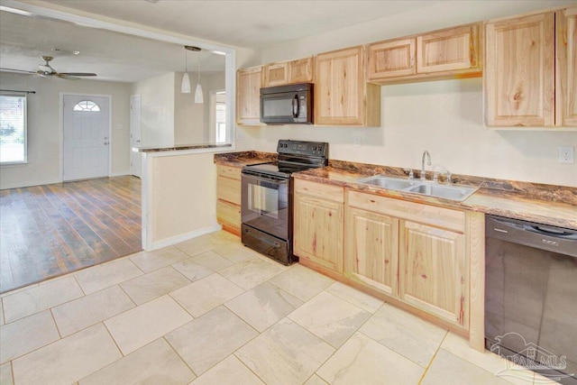 kitchen featuring black appliances, light wood-type flooring, decorative light fixtures, light brown cabinetry, and sink