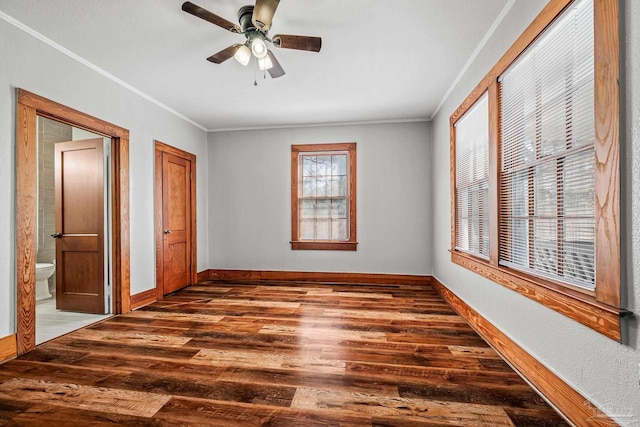 unfurnished bedroom with dark wood-style floors, baseboards, ornamental molding, and ceiling fan