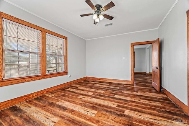 spare room with baseboards, visible vents, ceiling fan, wood finished floors, and crown molding