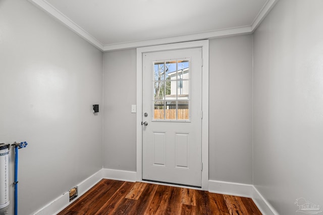 doorway featuring ornamental molding, dark wood finished floors, and baseboards