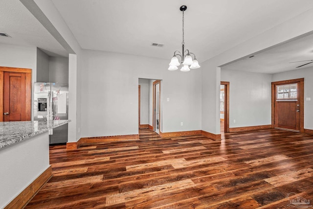 unfurnished dining area featuring baseboards, a notable chandelier, visible vents, and dark wood-style flooring