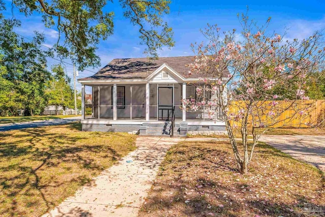 bungalow with a sunroom and a front lawn