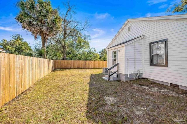 view of yard with entry steps, a fenced backyard, and cooling unit